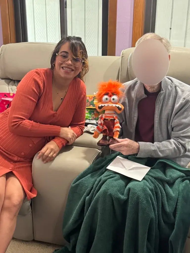 Ana seated beside an older adult whose face was obscured in the supplied photograph